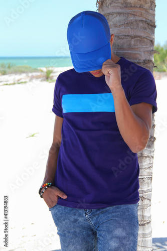 man whit blue cap and purple shirt at beach, mockup