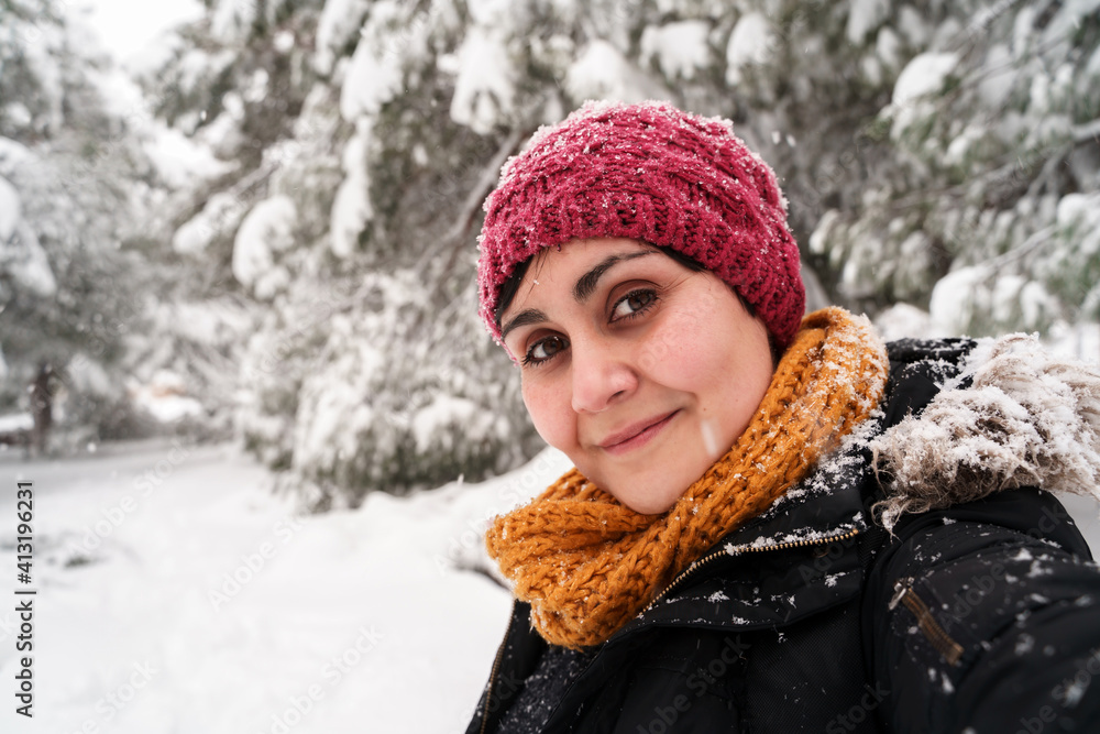 Horizontal portrait of young caucasian woman breathing fresh air outdoors under the snow. Environment and human contact with nature in winter under a snowstorm. Fresh air and nature concept. Horizontal portrait of young caucasian woman breathing fresh air outdoors under the snow. Environment and human contact with nature in winter under a snowstorm. Fresh air and nature concept.