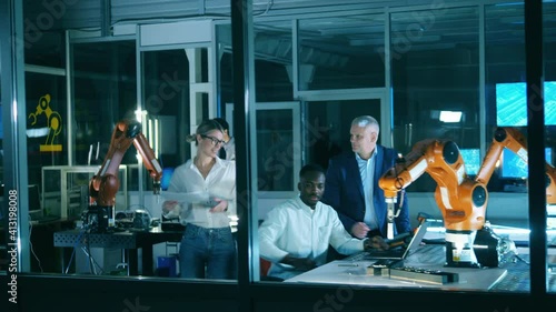 Professional engineers working at modern industrial laboratory. Scientists are experimenting with robots in the laboratory photo