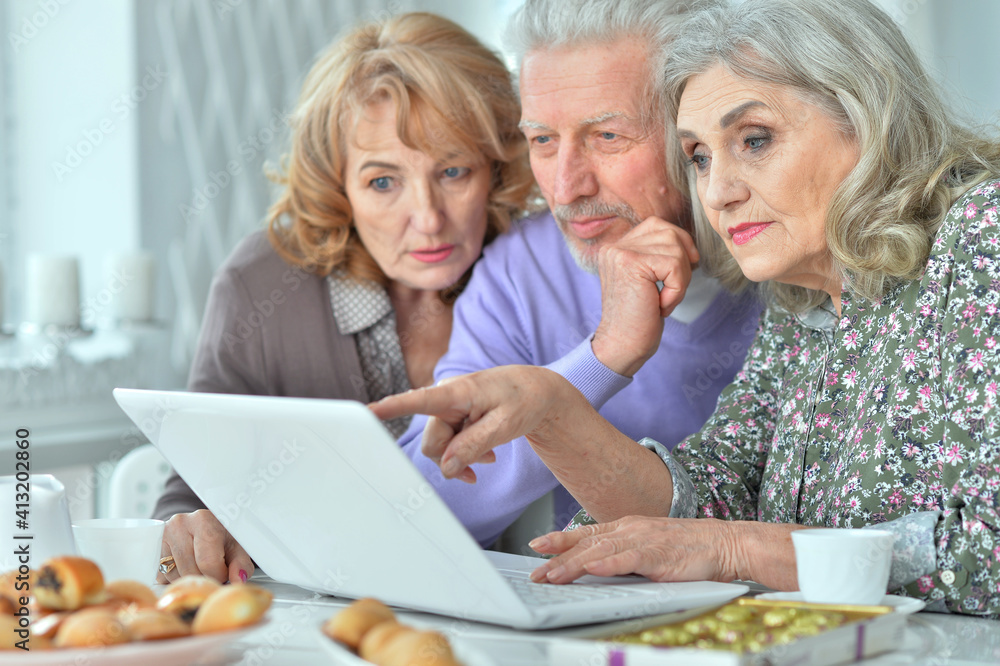 happy senior people with laptop drinking tea happy senior people with laptop drinking tea