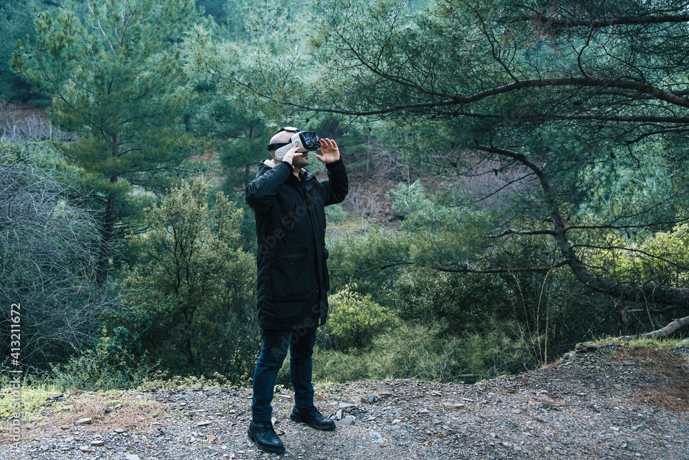 Man examining the forest with virtual reality glasses. Future technology vr 3D glasses to be used anywhere Man examining the forest with virtual reality glasses. Future technology vr 3D glasses to be used anywhere