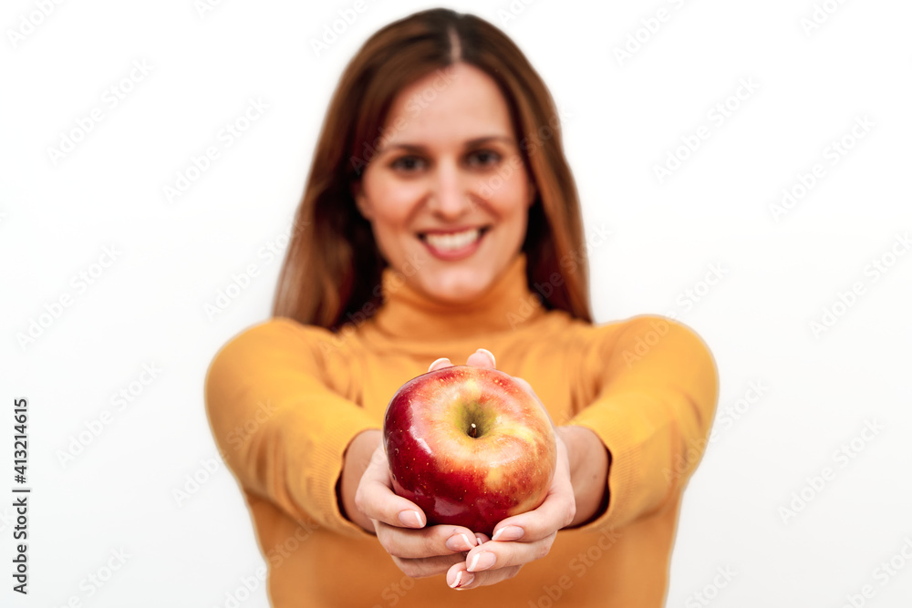 Front view of unrecognizable woman out of focus showing an apple in her hands. Concept of diet and weight control. Front view of unrecognizable woman out of focus showing an apple in her hands. Concept of diet and weight control.