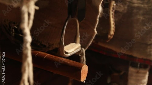A horse saddle and stirrups. Horse saddle for a western cowboy. A leather frame and metal stirrups