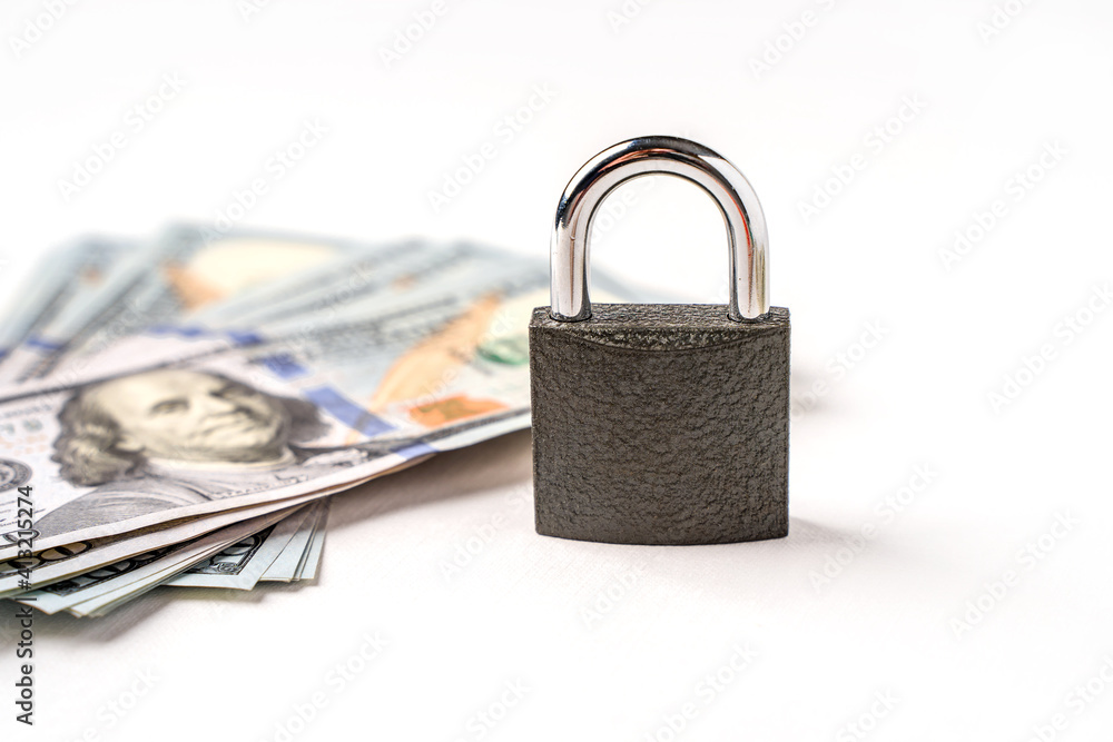 Locked lock on banknotes as a concept of financial security of deposits and money storage Locked lock on banknotes as a concept of financial security of deposits and money storage