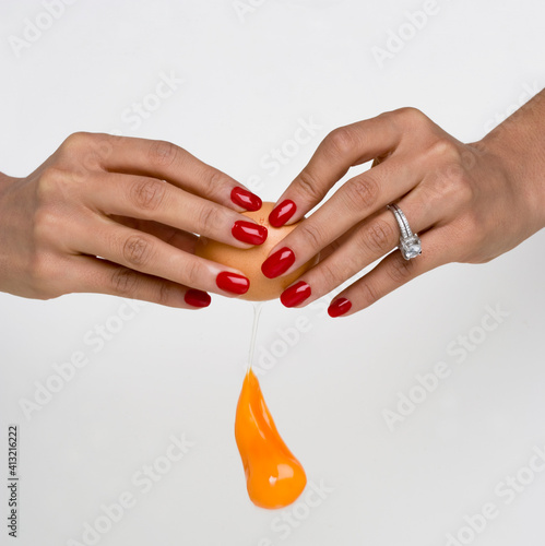mãos femininas com unhas pintadas a partir um ovo. photo