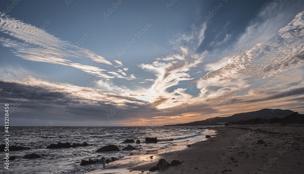 Obraz premium View of Sand and rock beach at dusk