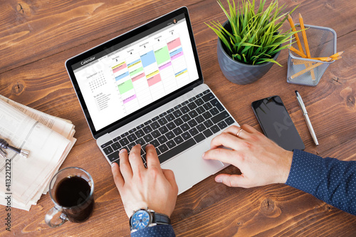 Man using calendar app on laptop at work