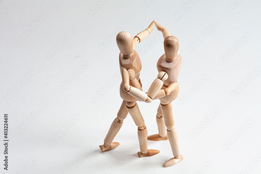 two wooden mannequins dancing and holding hands two wooden mannequins dancing and holding hands