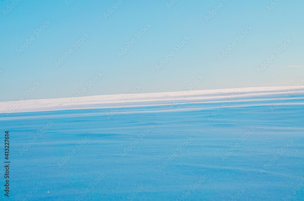 Pure white and blue winter landscape with a snow field without anyone