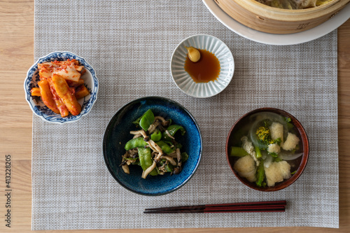 A simple lunch scene with miso soup and some other small meals. These are placed on grey lunch mat.  