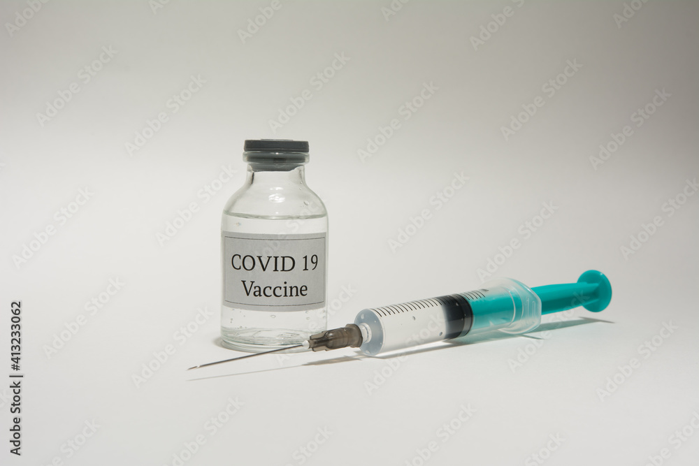 Covid 19 vaccine bottle and syringe on a white background. Covid 19 vaccine bottle and syringe on a white background.