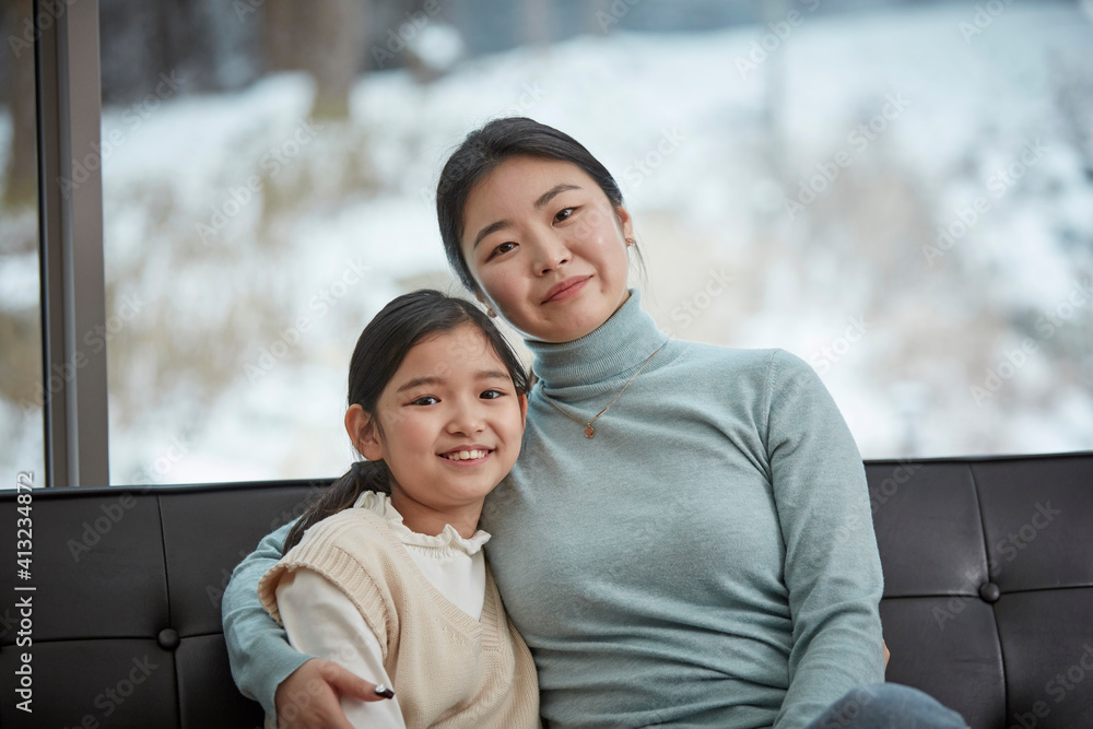 Little kid daughter and mother while sitting on sofa at home Little kid daughter and mother while sitting on sofa at home