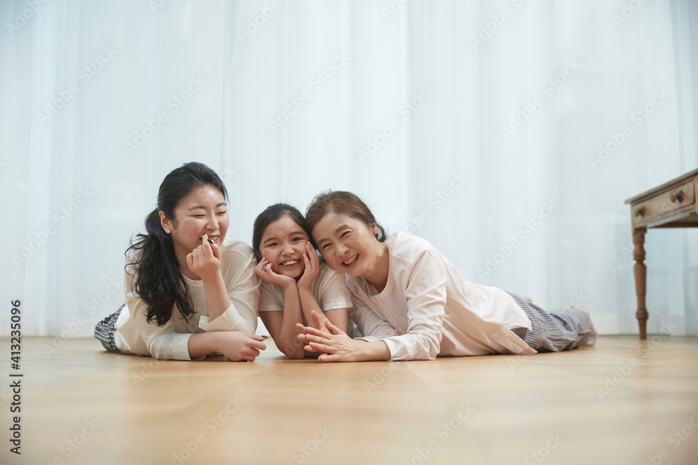 Little kid daughter and old mother while sitting on sofa at home Little kid daughter and old mother while sitting on sofa at home