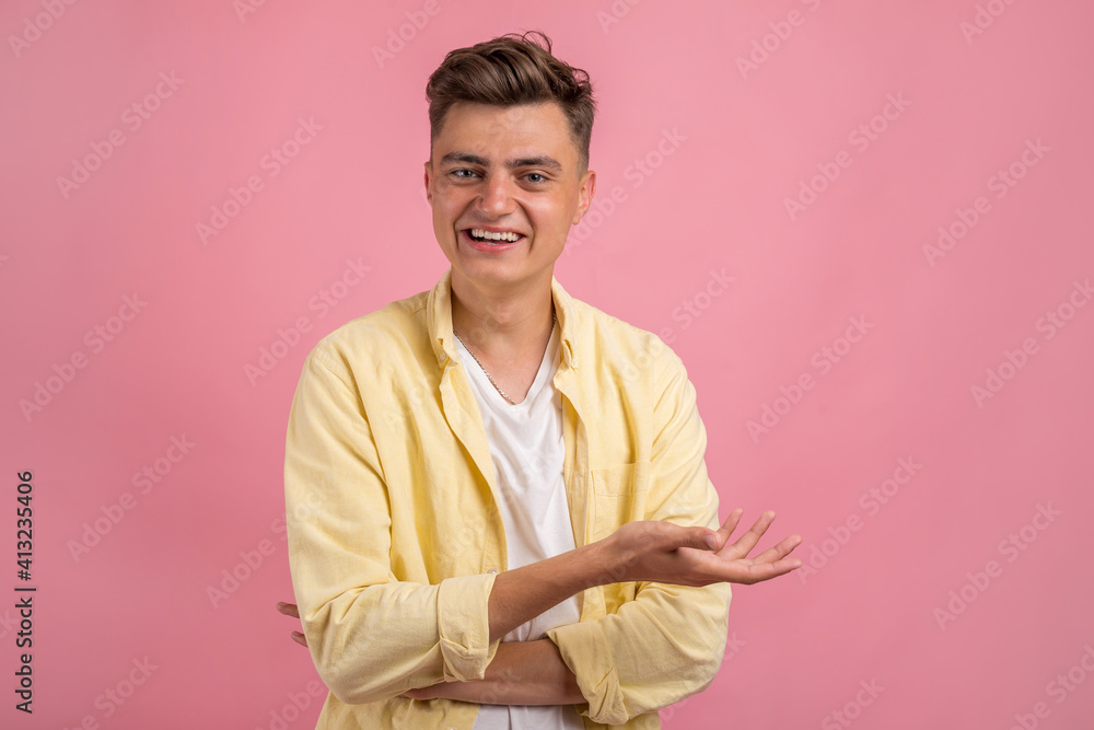 Obraz premium Happy smiling young man presenting and showing your text or product isolated on pink background