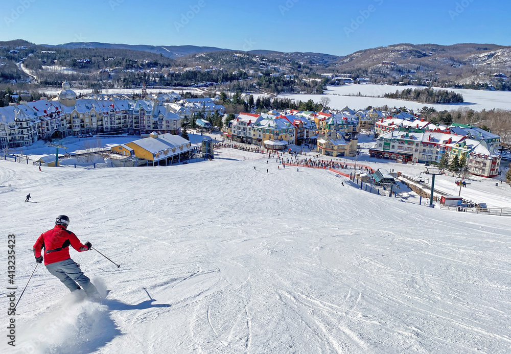 Fototapeta premium Skier on Mont Tremblant village resort in winter, Quebec, Canada