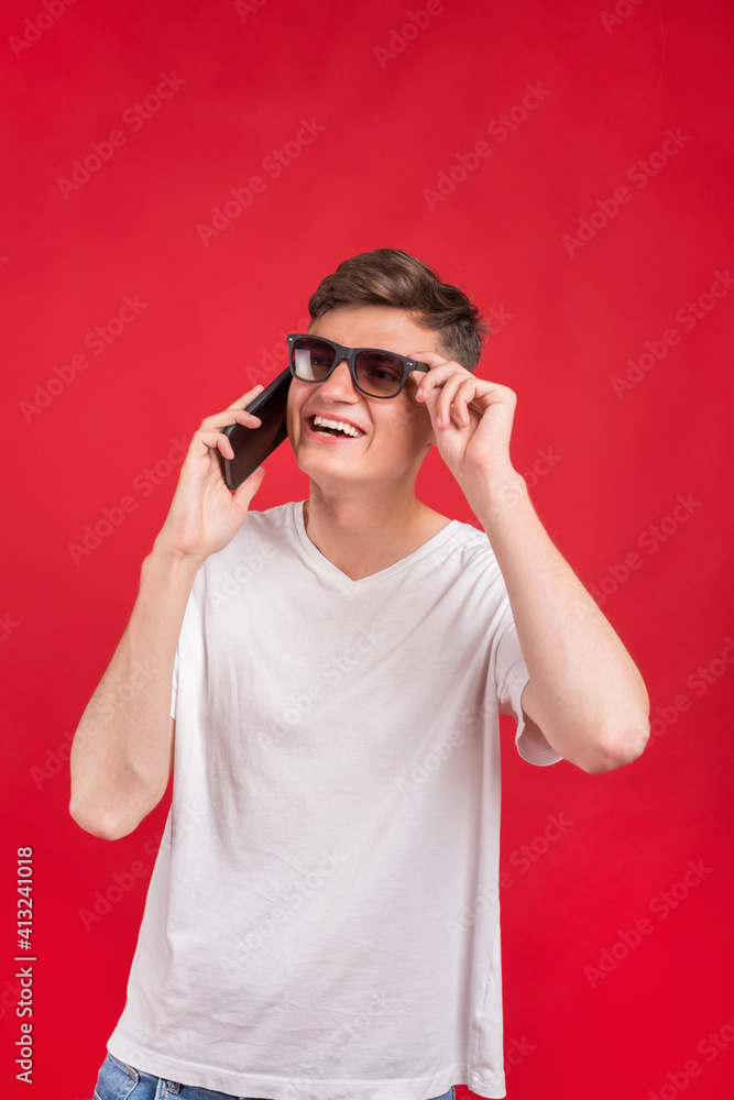 Handsome young man using his phone with smile while standing against red background.Young adult man talking on the phone scared in shock with a surprise face, afraid and excited with fear expressio
Handsome young man using his phone with smile while standing against red background.Young adult man talking on the phone scared in shock with a surprise face, afraid and excited with fear expressio