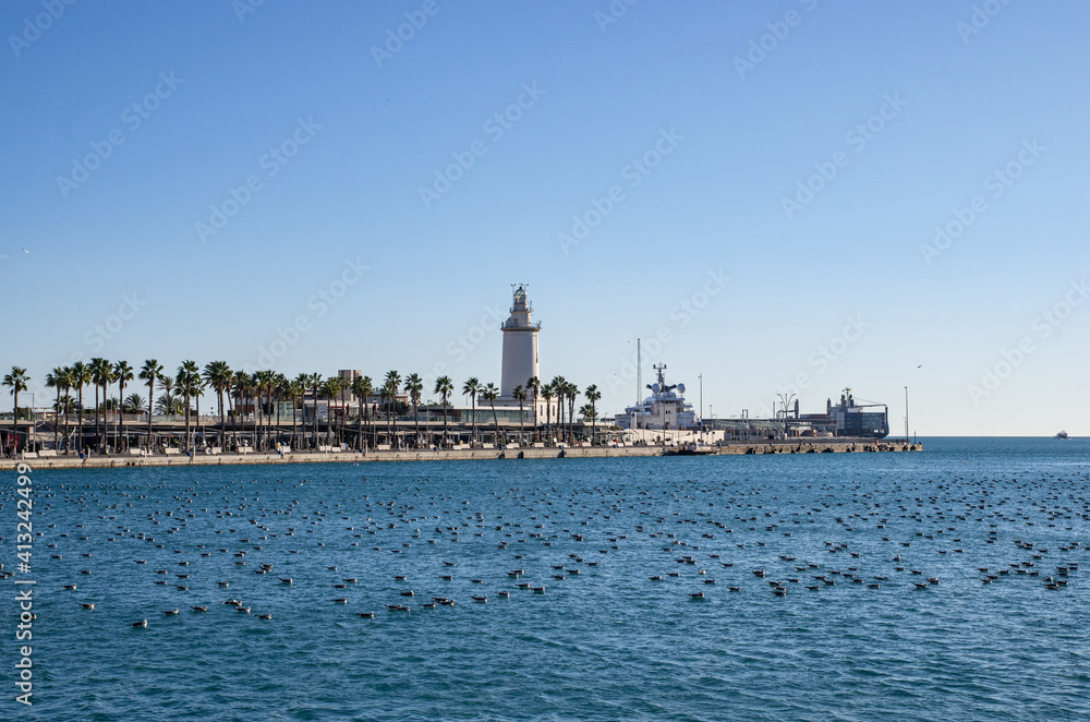 Port in Malaga and the lighthouse in the background. Malaga in Andalusia, Spain.