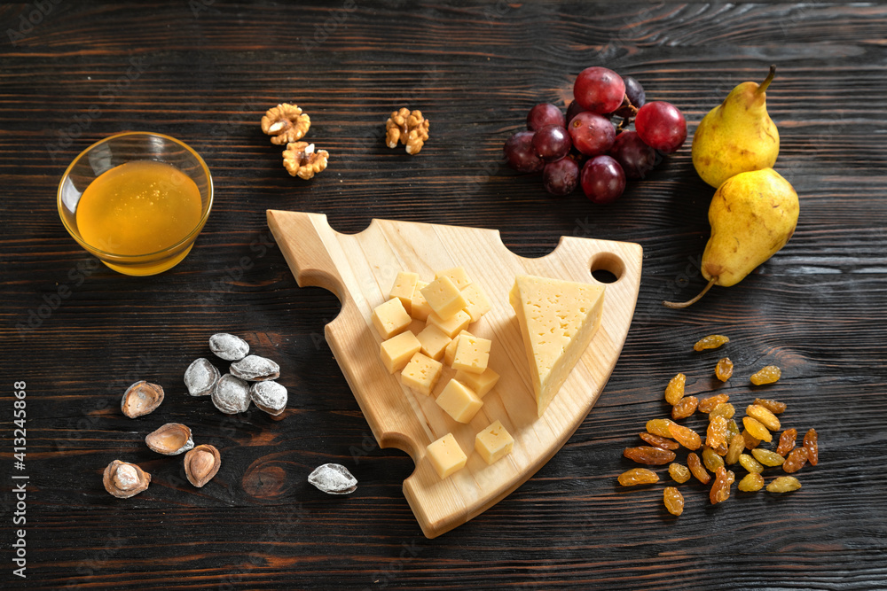 Cheese, pears and nuts on a wooden cutting board