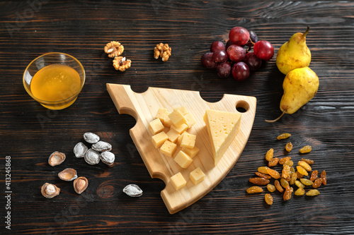 Obraz na płótnie Cheese, pears and nuts on a wooden cutting board w salonie