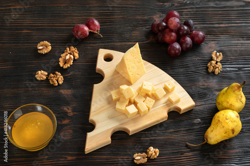 Obraz na płótnie Cheese, pears and nuts on a wooden cutting board w salonie
