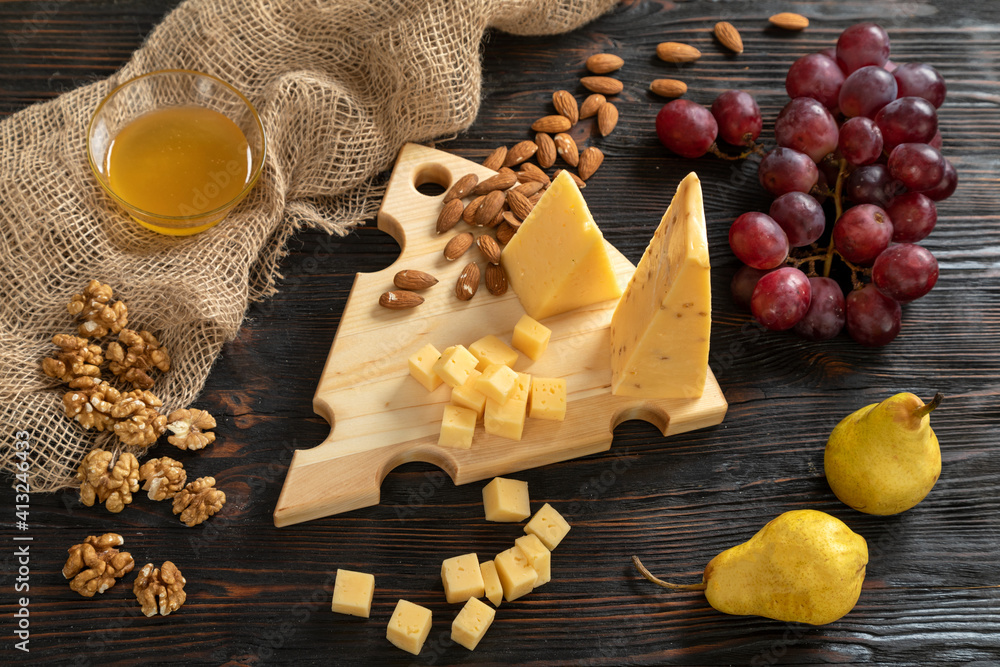 Cheese, pears and nuts on a wooden cutting board