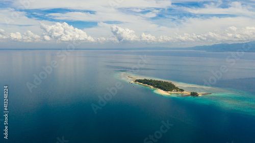 Top view of small tropical Little Liguid Island in the blue sea with a coral reef and the beach. Little Cruz Island, Philippines, Samal.