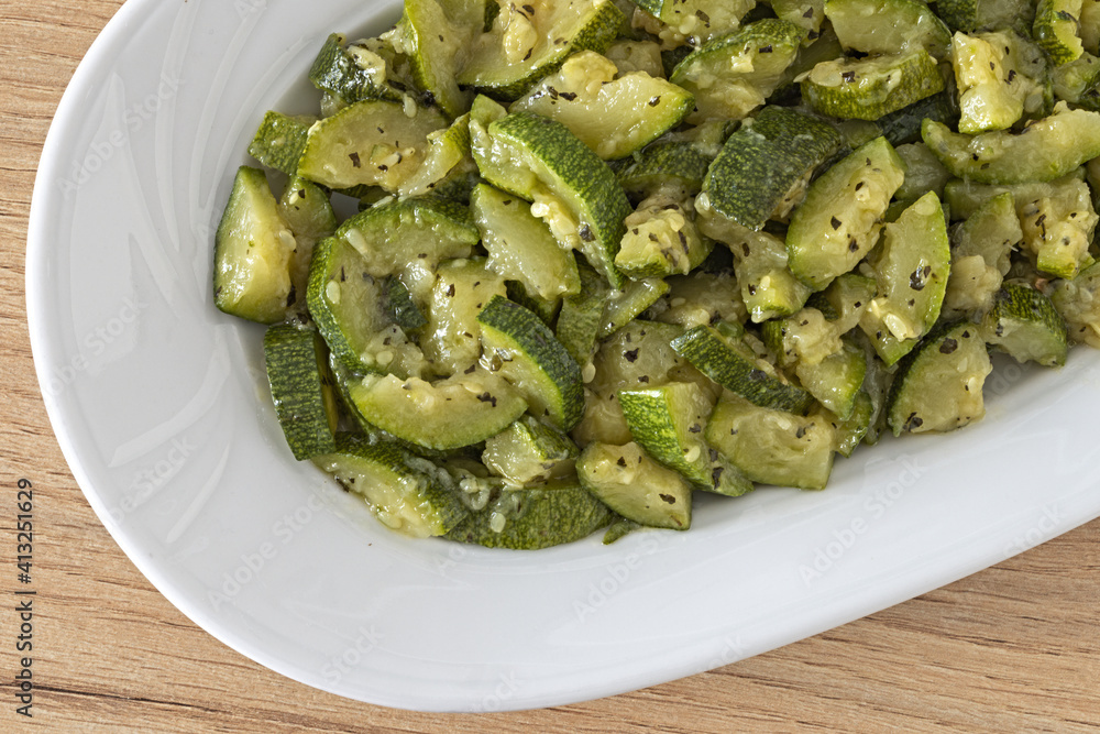 particolare piatto ovale con zucchine trifolate vista dall'alto particolare piatto ovale con zucchine trifolate vista dall'alto