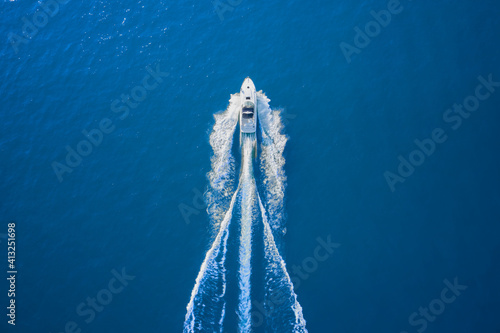 Motor boat in the sea. Aerial view luxury motor boat. Drone view of a boat sailing. Top view of a white boat sailing to the blue sea. Travel - image. © Berg