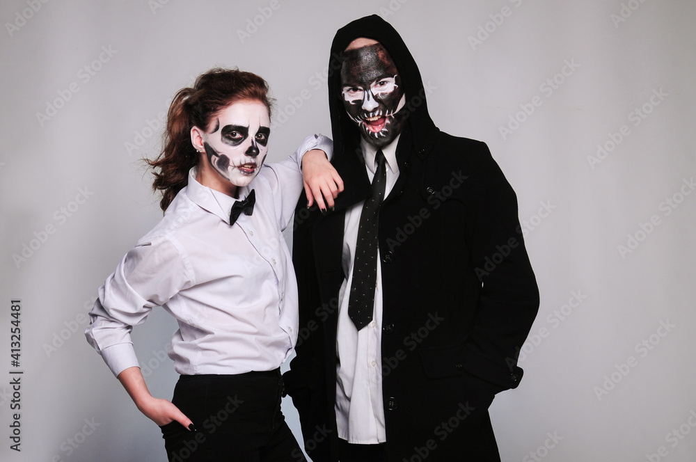 a girl and a man in Halloween makeup in the image of dead people with a black skull, wearing a black hoodie and a white shirt a girl and a man in Halloween makeup in the image of dead people with a black skull, wearing a black hoodie and a white shirt