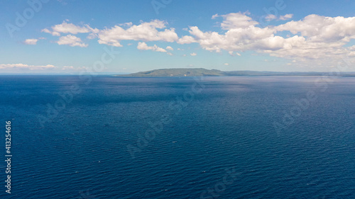 A erial seascape of Cebu island and blue sea against the sky with clouds.