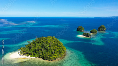 Aerial view of Tropical island with sand beach, palm trees by atoll with coral reef. Britania Islands, Surigao del Sur, Philippines. © Alex Traveler