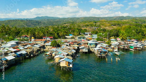 Fishing village with wooden houses on stilts in the sea. Village of fishermen with houses on the water, with fishing boats. Zamboanga city, Philippines, Mindanao.