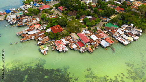 Village of fishermen with houses on the water, with fishing boats in Tagbilaran city. Bohol, Philippines. photo