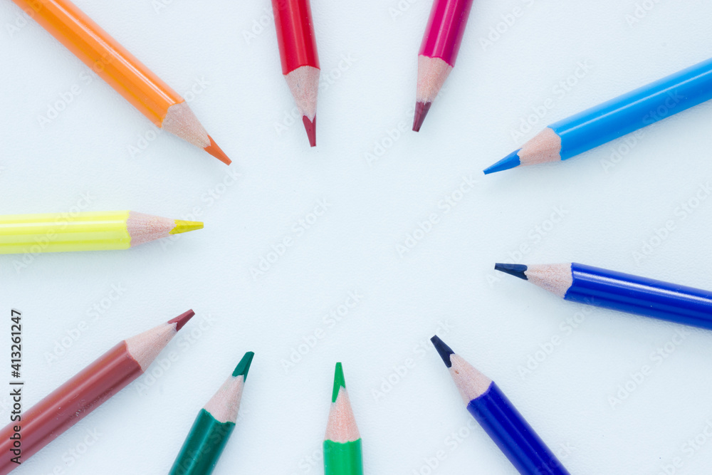 Colorful pencils in a circle pointing to the middle on white background Colorful pencils in a circle pointing to the middle on white background