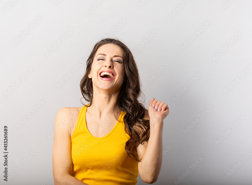 Beautiful happy laughing woman with open smiling mouth on blue background with empty copy space. Positive Beautiful happy laughing woman with open smiling mouth on blue background with empty copy space. Positive