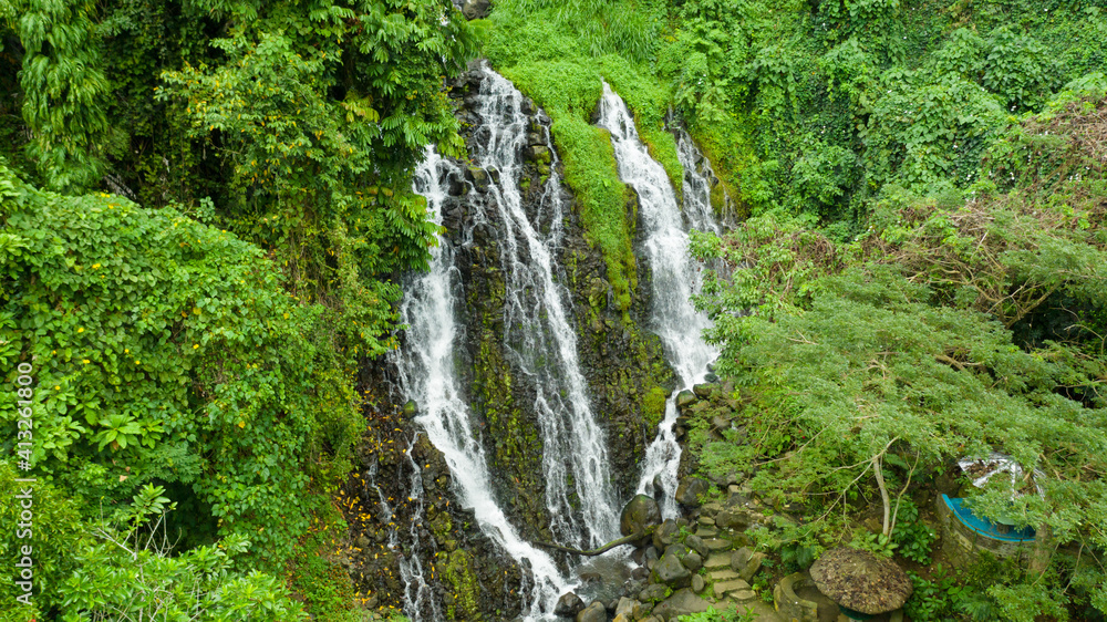 Waterfall in the green forest. Mimbalut Falls in the jungle, island of Mindanao, Philippines. Iligan City, Lanao del Norte.