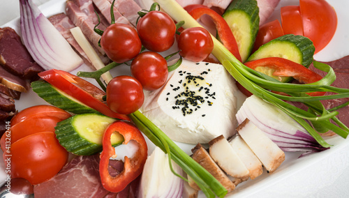 Close up view of a plateau with Romanian traditional aperitif food cheese tomatoes vegetables meat details