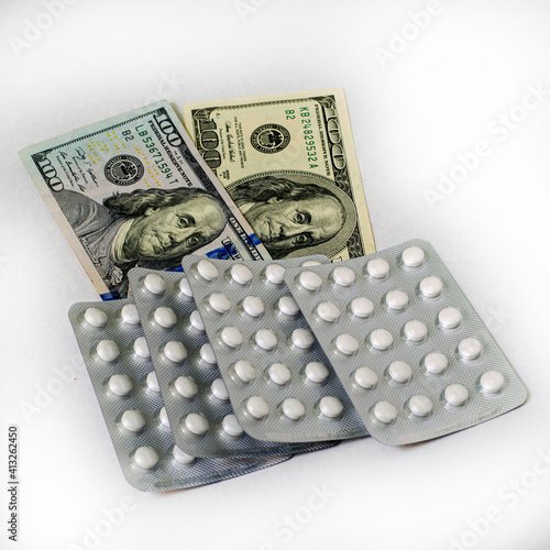 concept pharmaceutical business blisters with pills are on hundred dollar bills