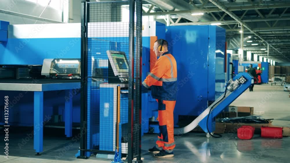 Specialist operating an industrial machine at a modern industrial plant Specialist operating an industrial machine at a modern industrial plant