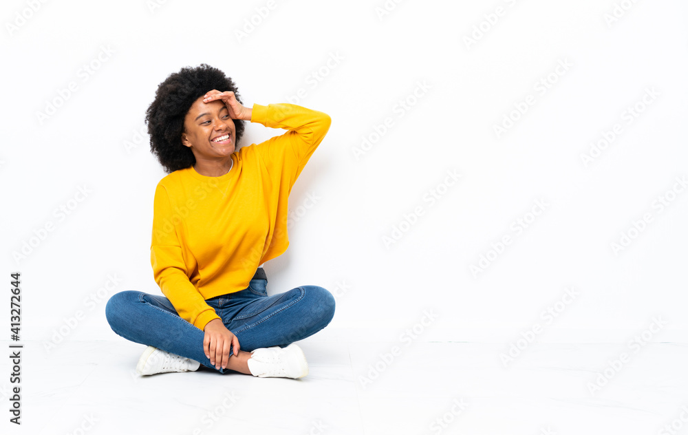 Young African American woman sitting on the floor has realized something and intending the solution Young African American woman sitting on the floor has realized something and intending the solution