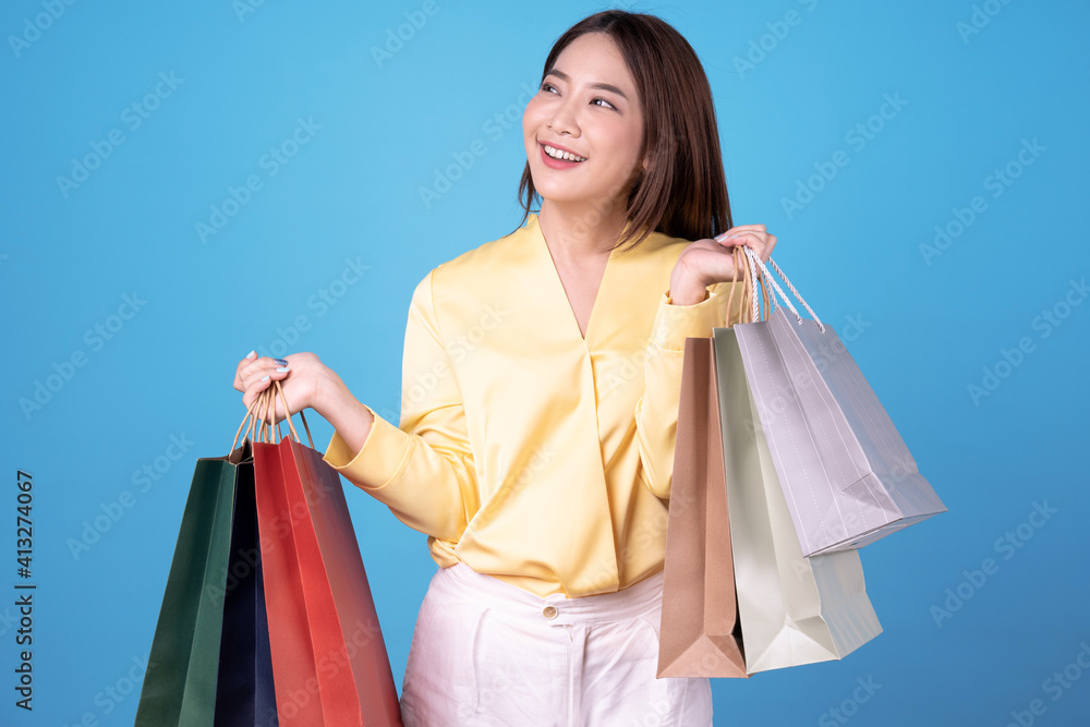 Young asian women are happy to go shopping, isolated on blue background.