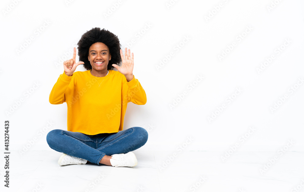 Young African American woman sitting on the floor counting seven with fingers Young African American woman sitting on the floor counting seven with fingers
