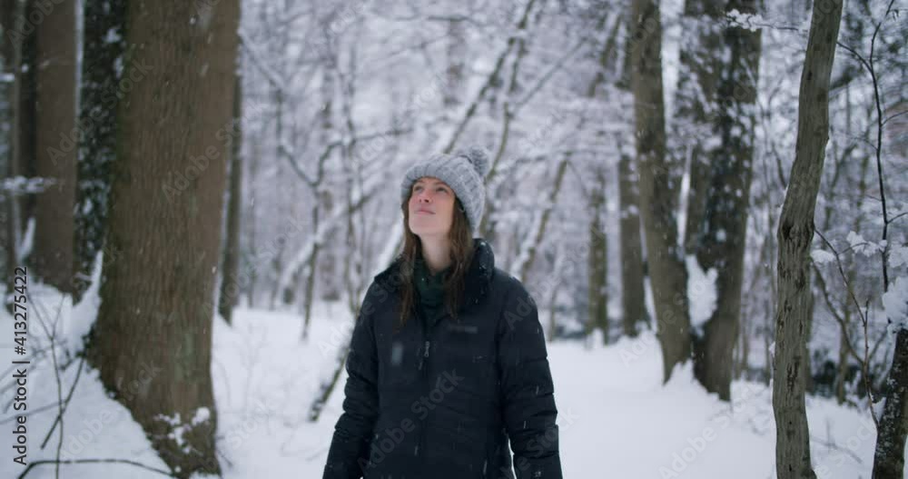 Hero shot of girl in snowy forest smiling at the camera Hero shot of girl in snowy forest smiling at the camera