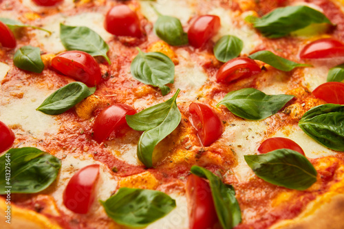 Traditional italian Pizza margarita with cheese, tomato and basil on green grass background