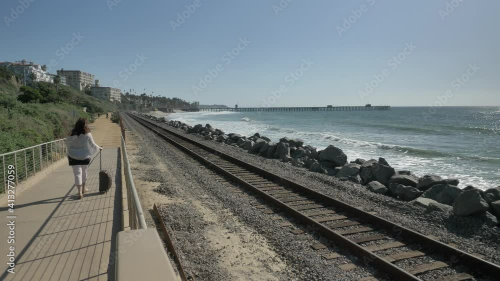 Woman with suitcase at railroads track Orange County San Clemente Linda Lane Park California USA Woman with suitcase at railroads track Orange County San Clemente Linda Lane Park California USA