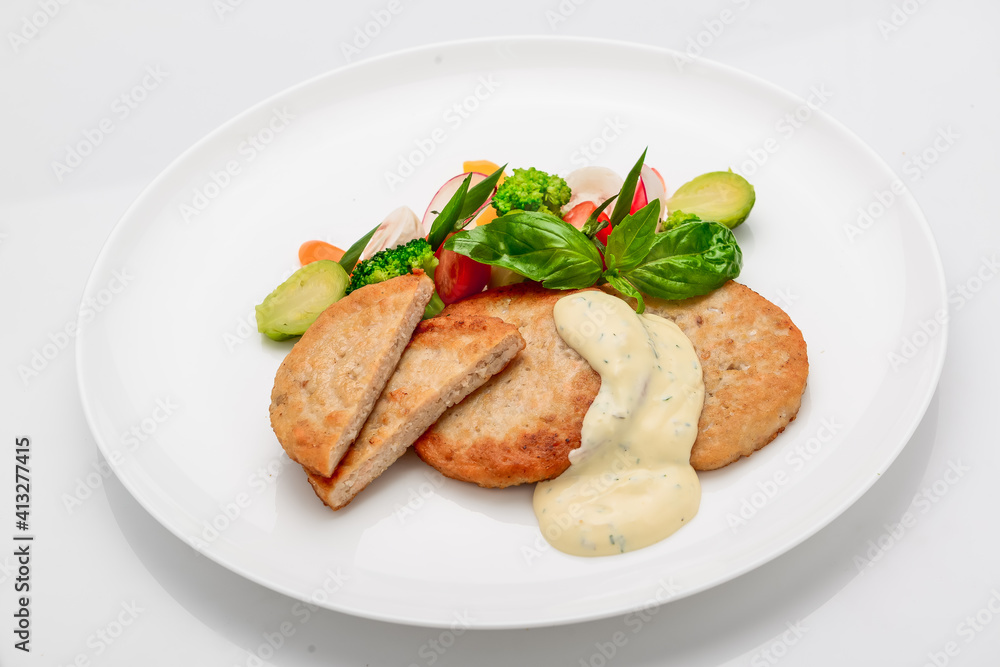 schnitzel, chicken cutlet with white sauce and vegetables
