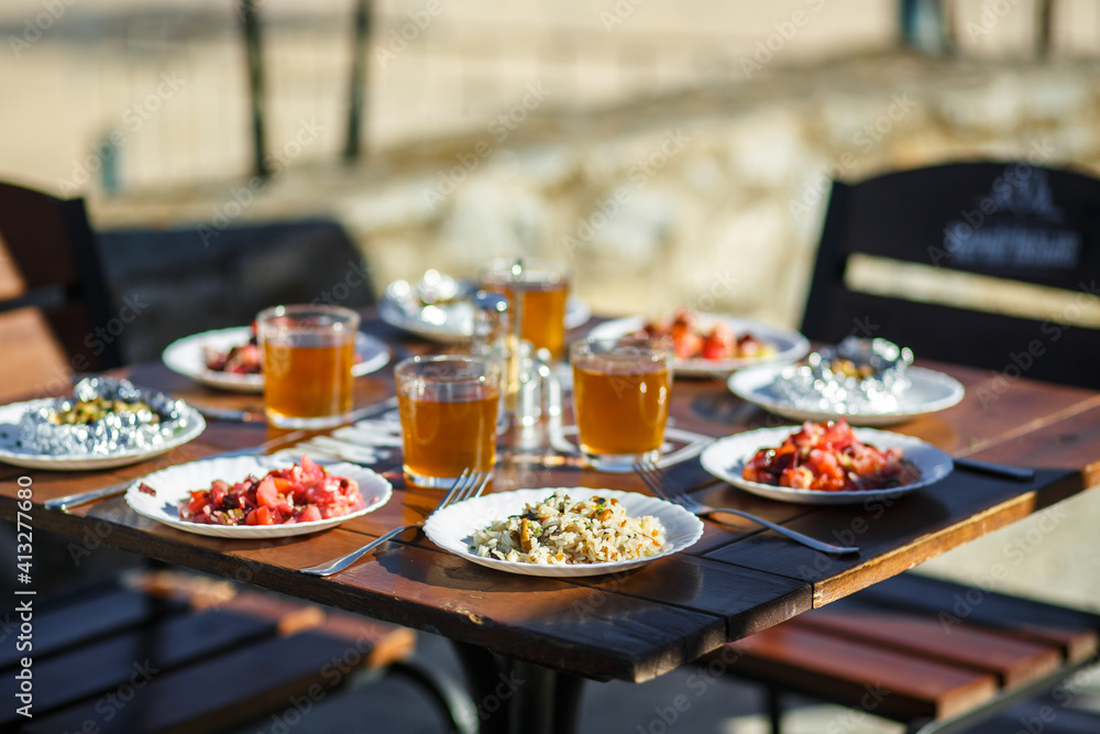 Plates with food on a wooden table on a summer terrace in a cafe Plates with food on a wooden table on a summer terrace in a cafe