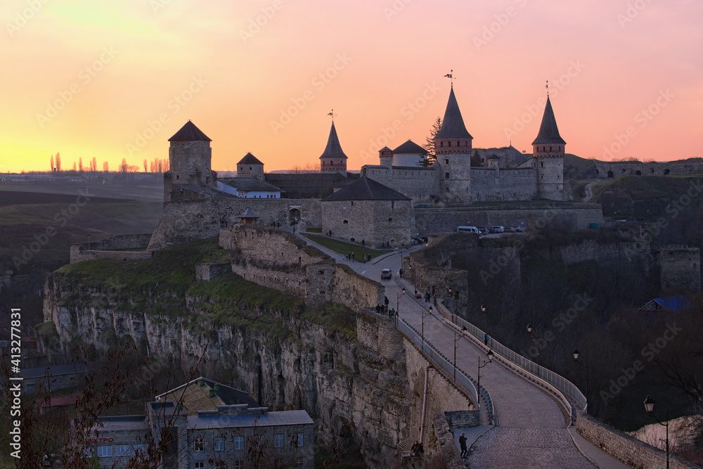 Winter landscape of ancient Kamianets-Podilskyi Castle during sunset. Colorful vibrant sky. Major tourist attraction in Kamianets-Podilskyi. Famous touristic place and travel destination. Ukraine
