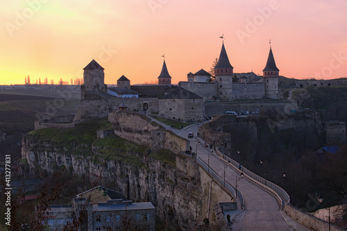 Winter landscape of ancient Kamianets-Podilskyi Castle during sunset. Colorful vibrant sky. Major tourist attraction in Kamianets-Podilskyi. Famous touristic place and travel destination. Ukraine