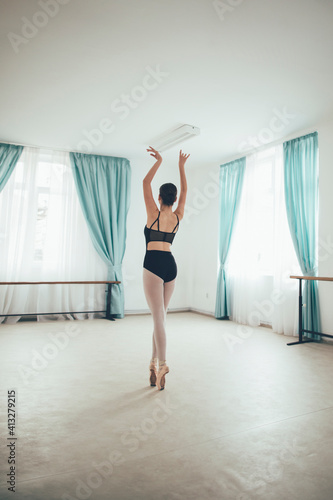 Rear view of young ballerina is doing classical ballet